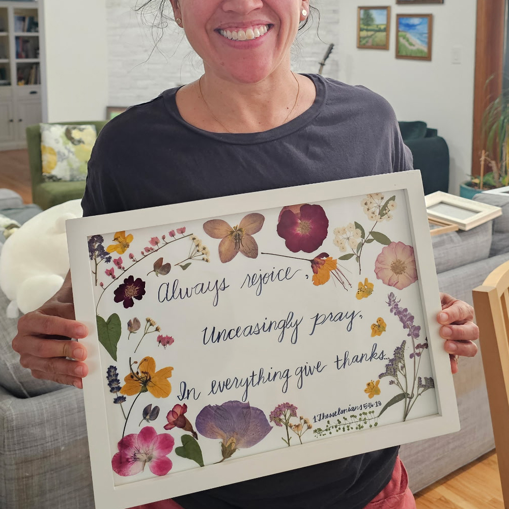 Framed calligraphy reading Always rejoice, unceasingly pray, in everything give thanks, bordered by pressed flowers